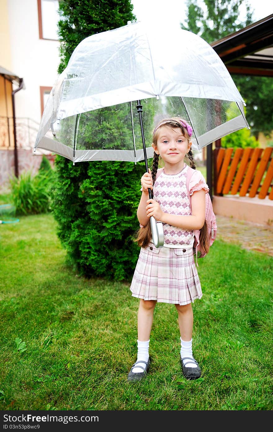 Brunette schoolgirl with backpack under umbrella on a rainy day. Brunette schoolgirl with backpack under umbrella on a rainy day