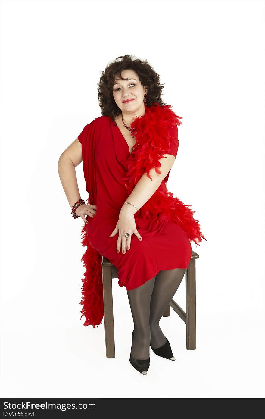 Lady in red dress on chair looking at camera