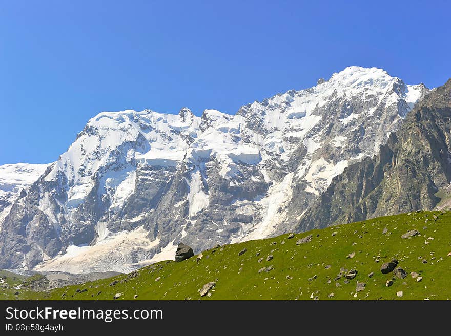 Mountain landscape with green field and stones