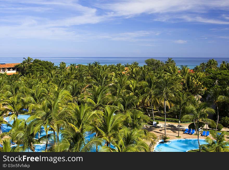 Beautiful view at midday on a poolside and sea up to the horizon from the hotel balcony. Beautiful view at midday on a poolside and sea up to the horizon from the hotel balcony