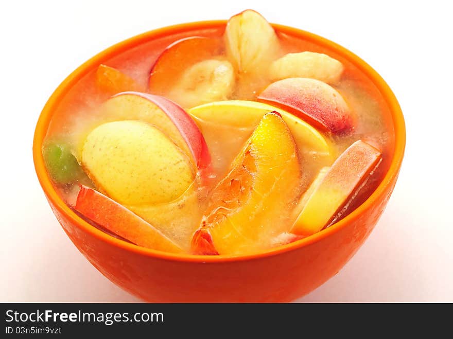 Orange bowl with frozen fruits and water. Orange bowl with frozen fruits and water