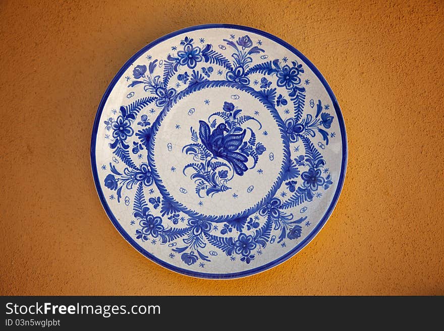 Spanish traditional ceramic plate on an orange wall