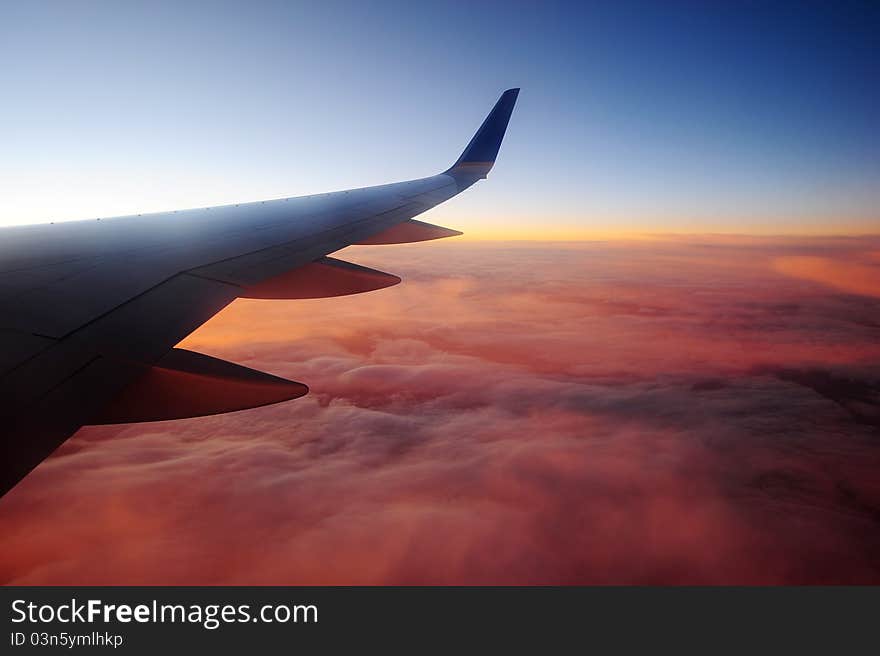 Fire color of glowing cloud as seen from plane during sunset. Fire color of glowing cloud as seen from plane during sunset