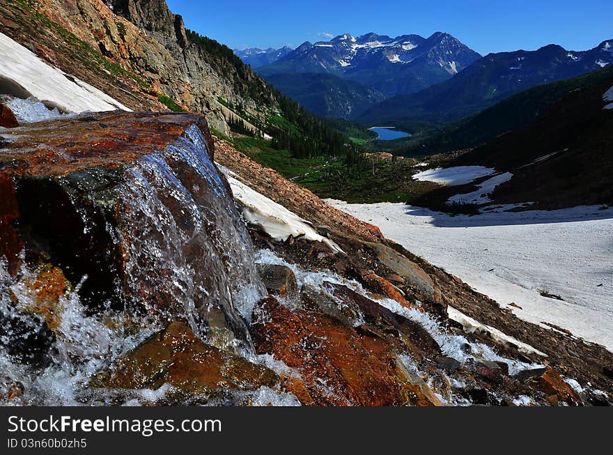 A waterfall with snow, mountains and a beautiful lake. A waterfall with snow, mountains and a beautiful lake