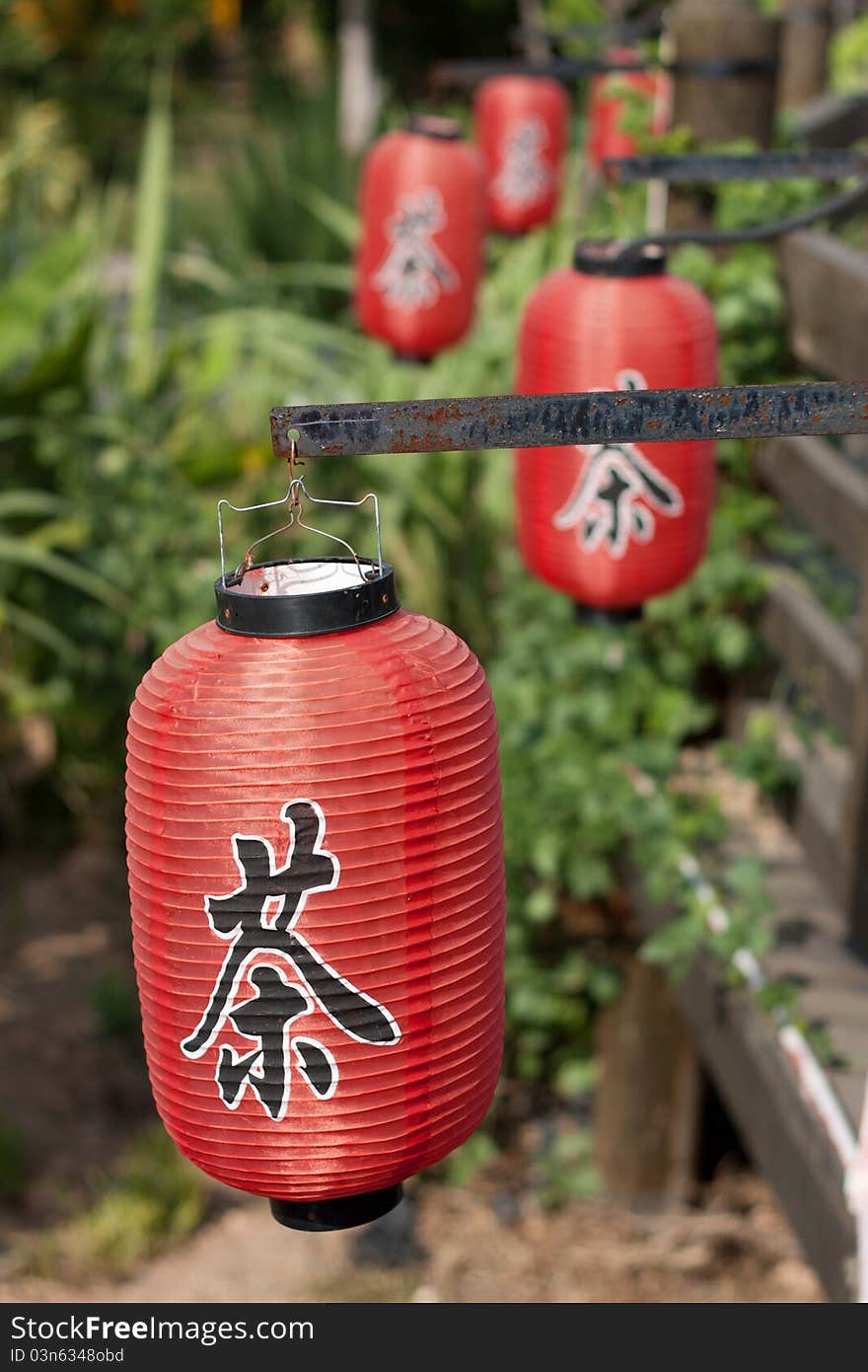 Red lanterns on wooden bridge, with Chinese letters tea printed, which is a Chinese traditional culture. Red lanterns on wooden bridge, with Chinese letters tea printed, which is a Chinese traditional culture.