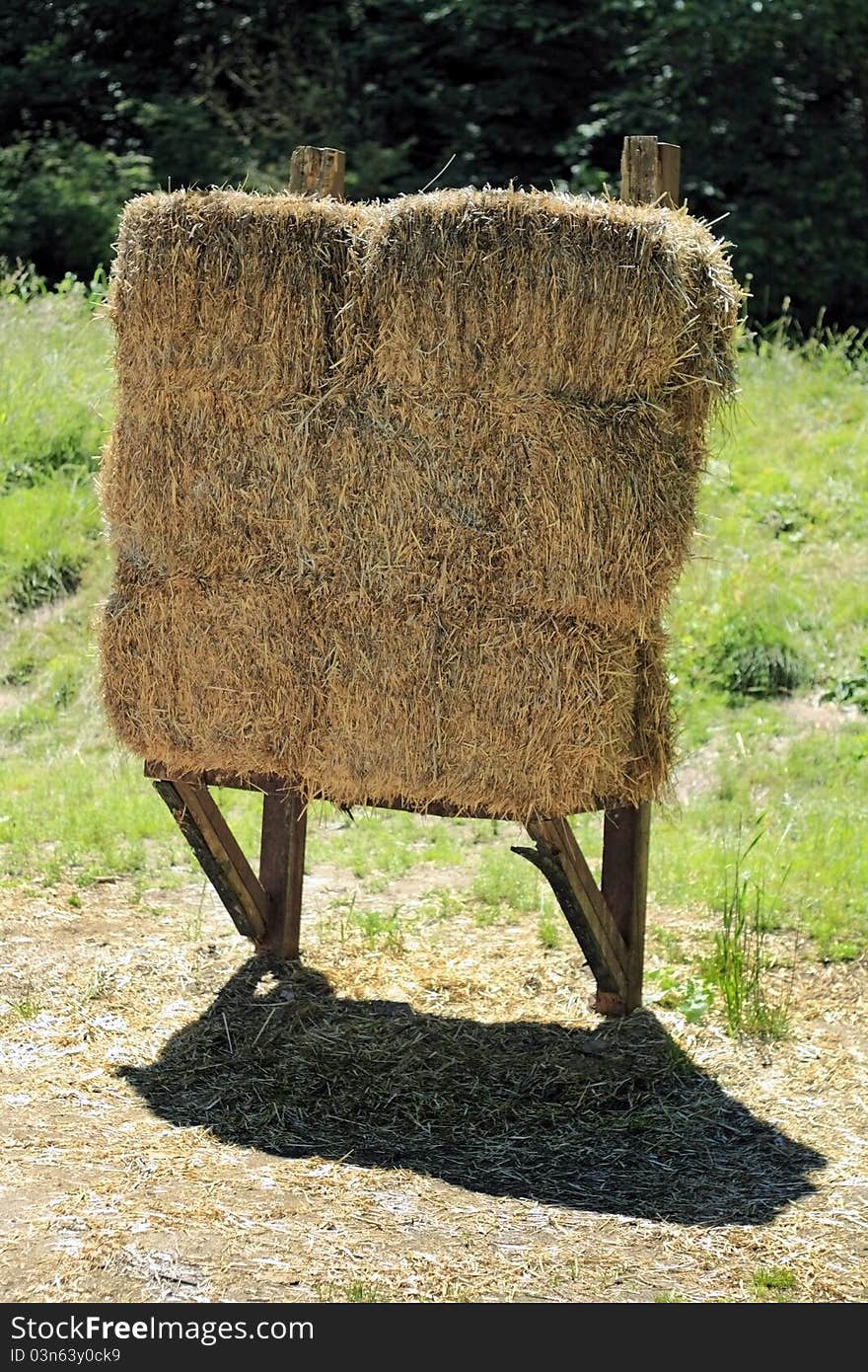 One hay bay backstop for archery targets outdoor in a sunny summer field. One hay bay backstop for archery targets outdoor in a sunny summer field.