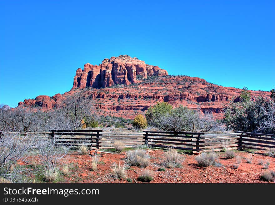 A wooden fence borders private property at the base of a red rock mountain in Sedona, Arzona. A wooden fence borders private property at the base of a red rock mountain in Sedona, Arzona.