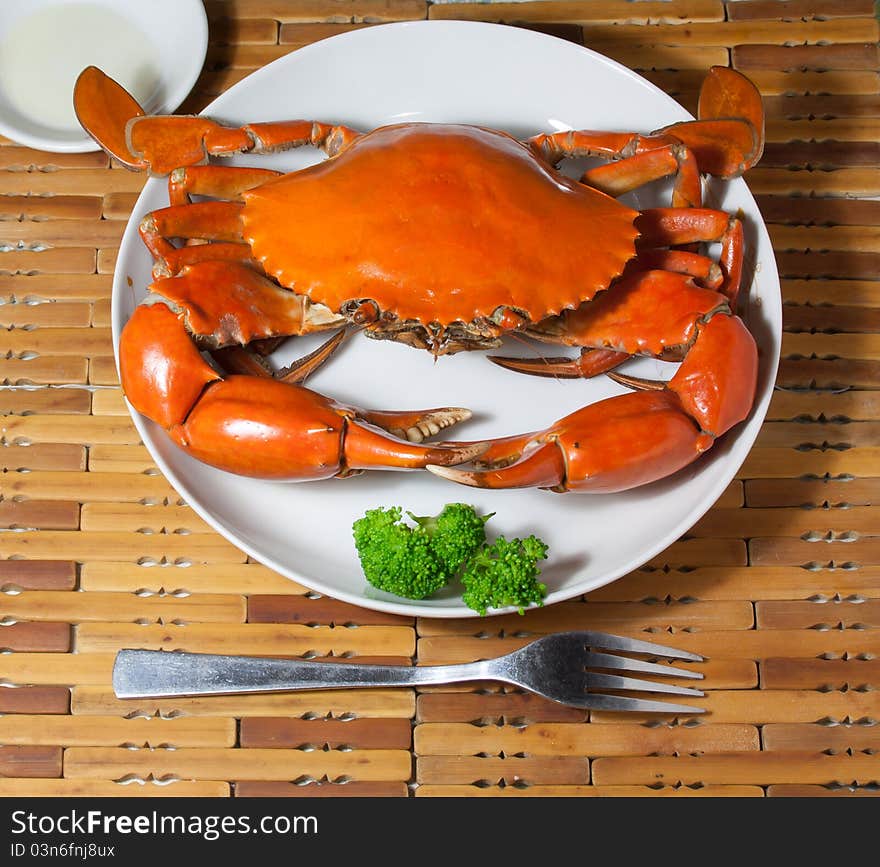 This is a dish of delicious crab, rosy and, green broccoli ornament on it,Fork in the front. This is a dish of delicious crab, rosy and, green broccoli ornament on it,Fork in the front.