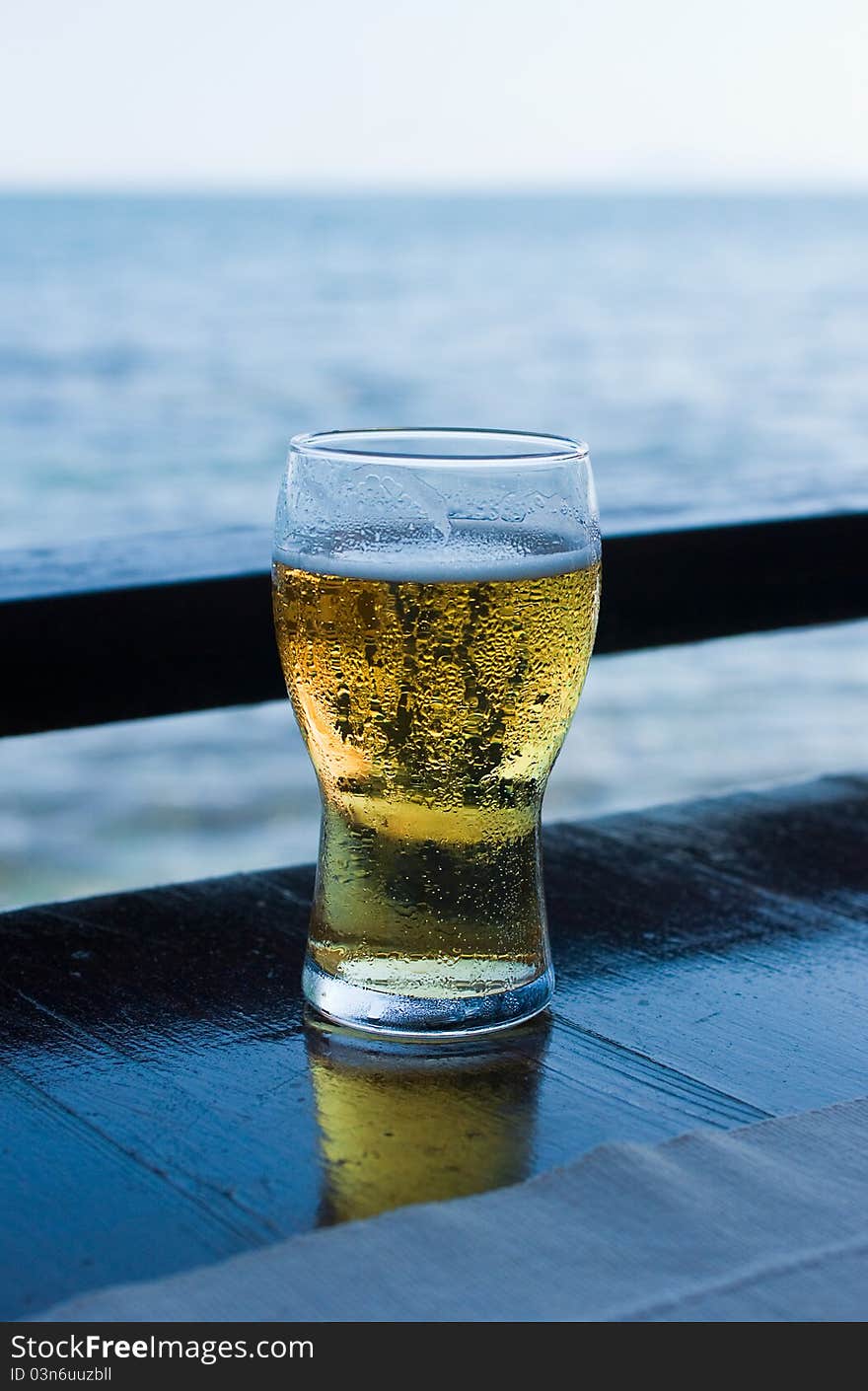 Glass of beer against sea