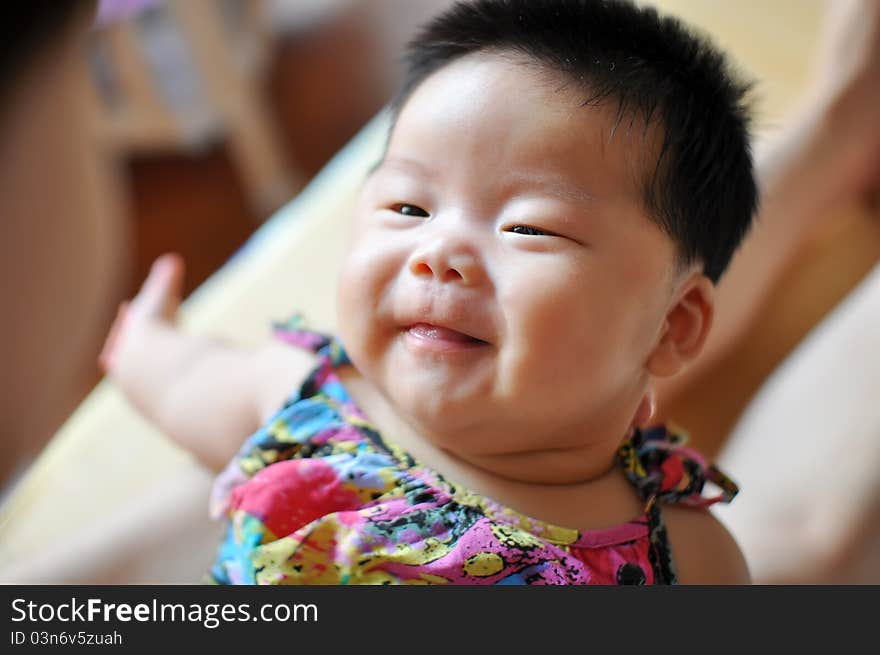 A 2 months chinese Baby girl smiling to her mother. A 2 months chinese Baby girl smiling to her mother