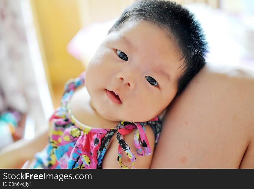 A 2 months chinese Baby girl lying on her mom's legs