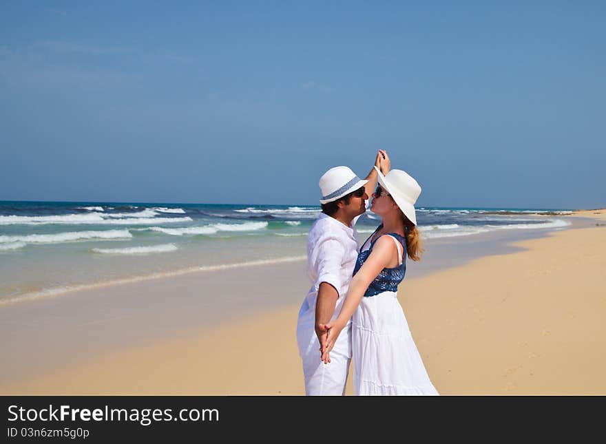 Honeymooners, young couple in white clothes dancing on a sea coast. Honeymooners, young couple in white clothes dancing on a sea coast