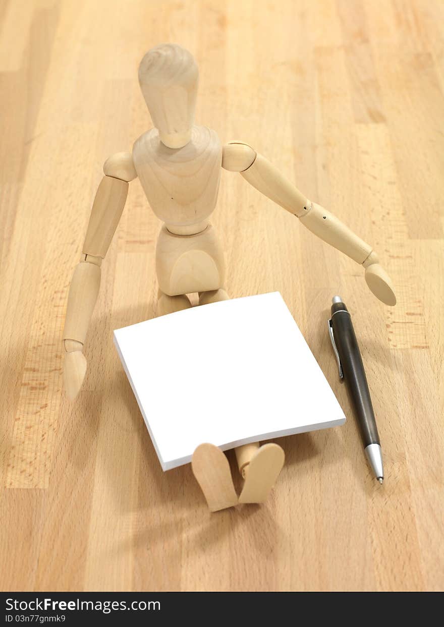 A wooden manikin on a wooden floor