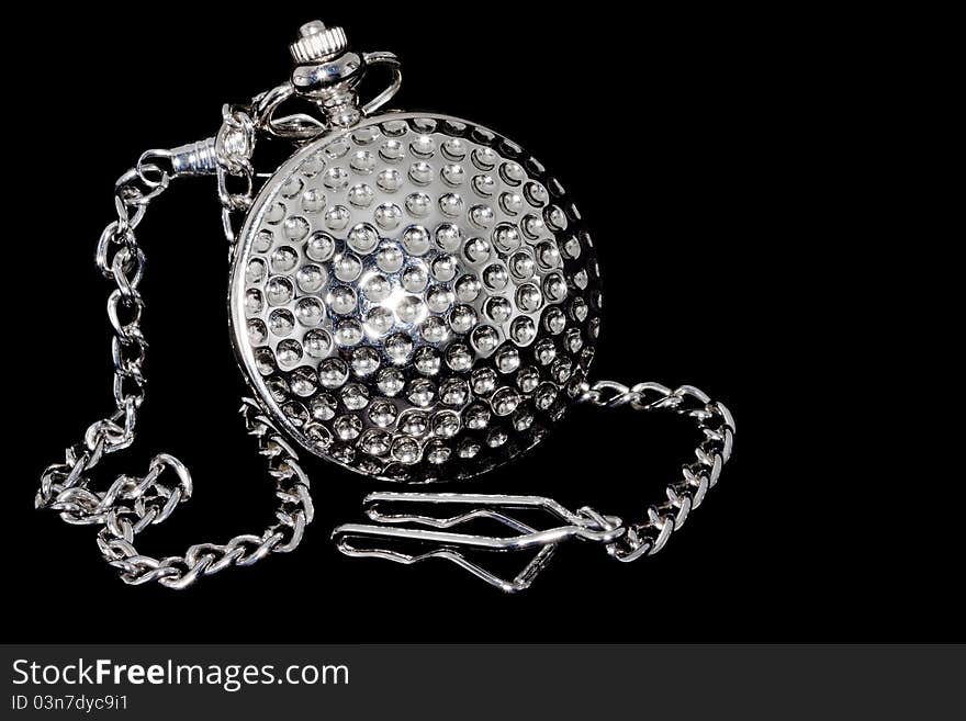 Closed old pocket watch with chain at black background