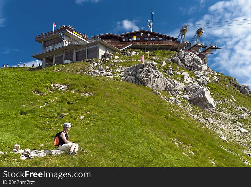 Woman sitting at the summit station of the Nebelhorn cable car. Woman sitting at the summit station of the Nebelhorn cable car