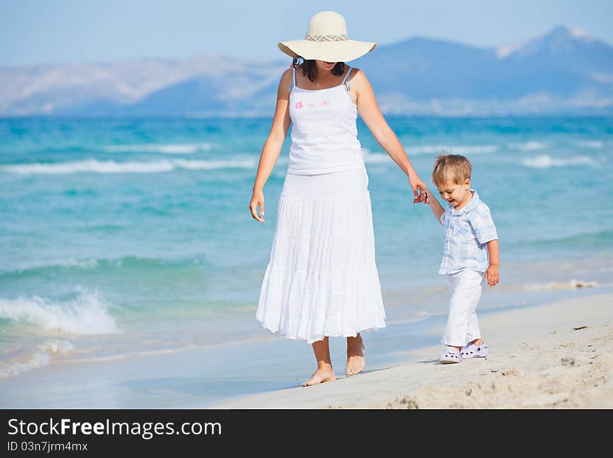 Young mother with her son on beach vacation