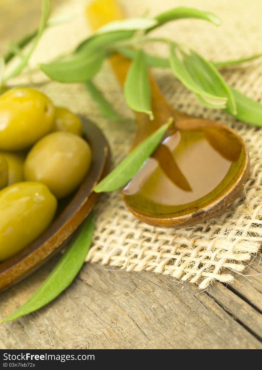 In the spoon with fresh olives on the wooden table. In the spoon with fresh olives on the wooden table