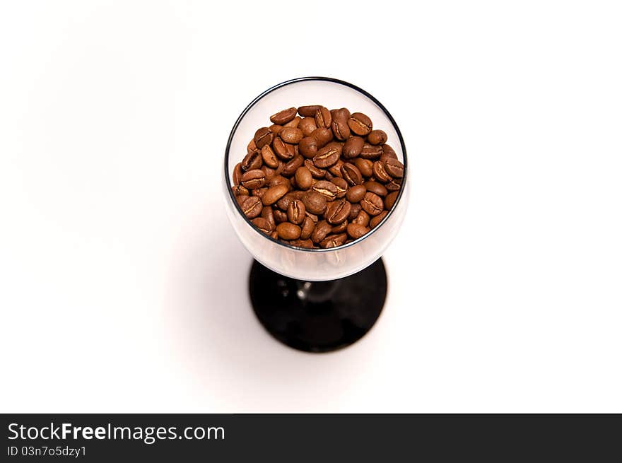 Coffee beans in glass cup on white background