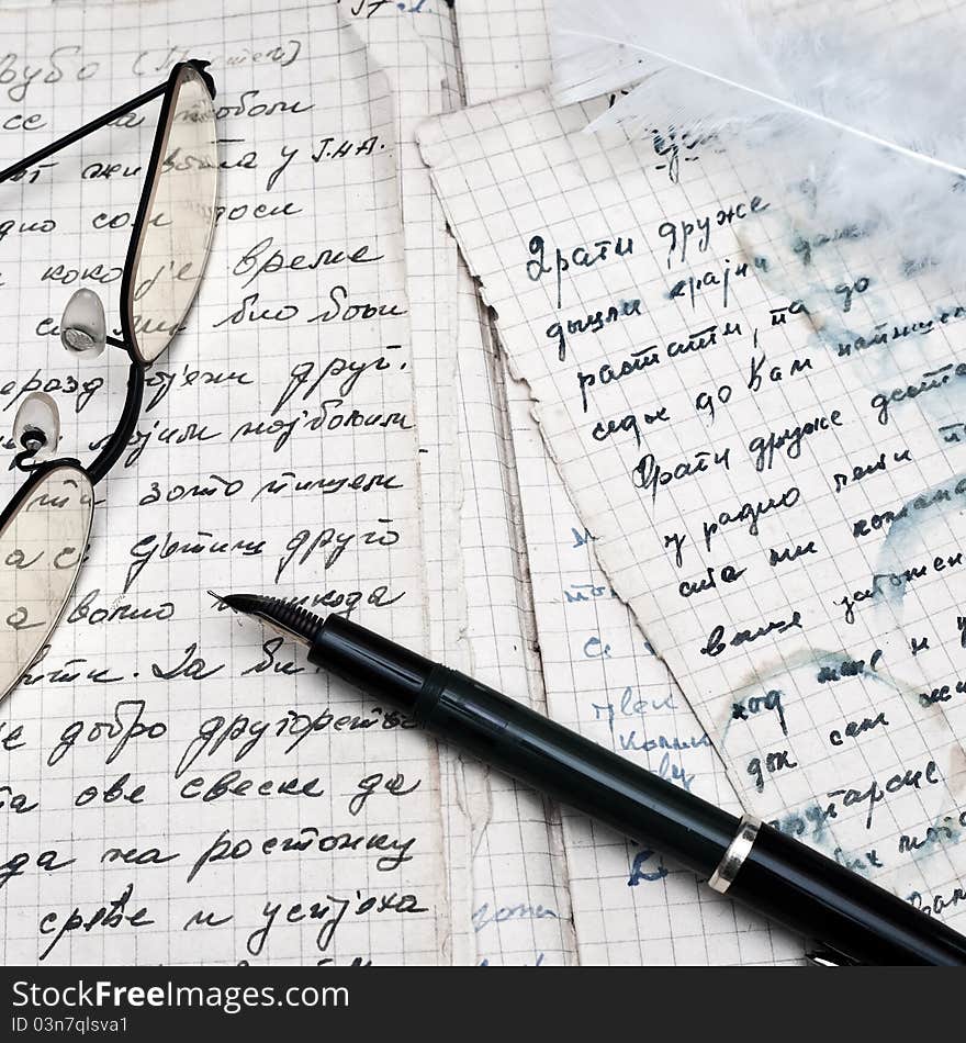 Fountain pen and eyeglasses over ancient writings.close up photo