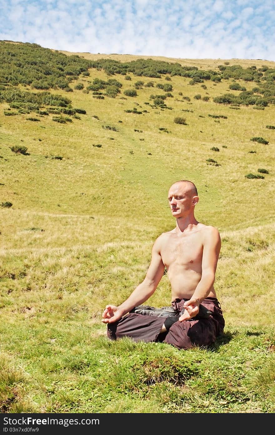 Man meditating at the foot of the mountain