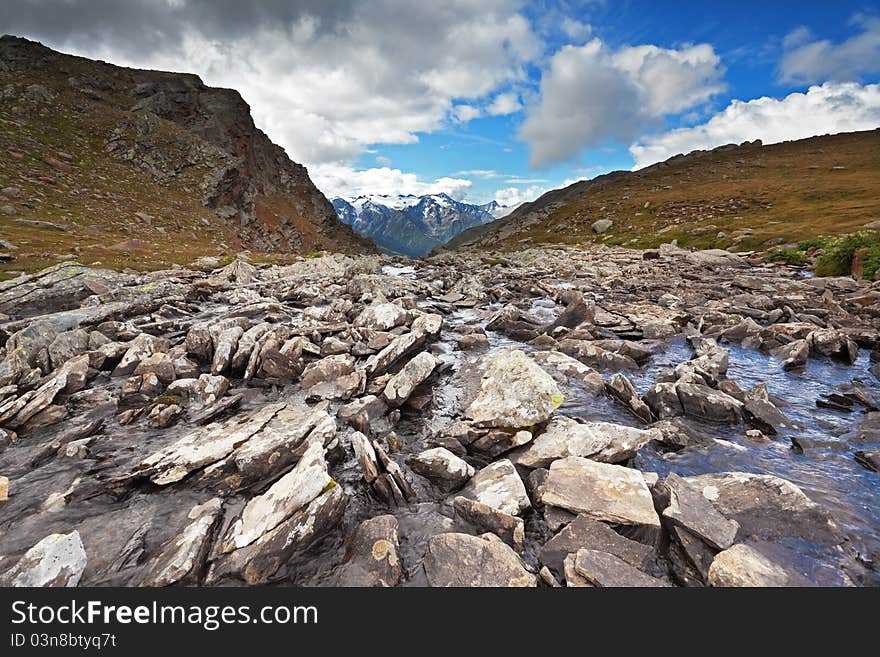 Small lake in high mountain during summer with a bed of stones. Small lake in high mountain during summer with a bed of stones