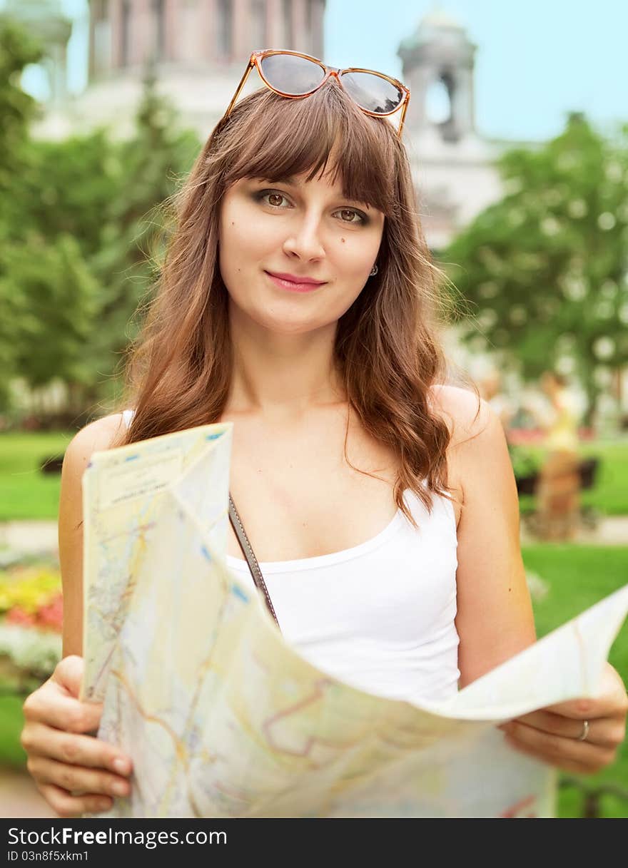 Portrait of happy young tourist girl with the map