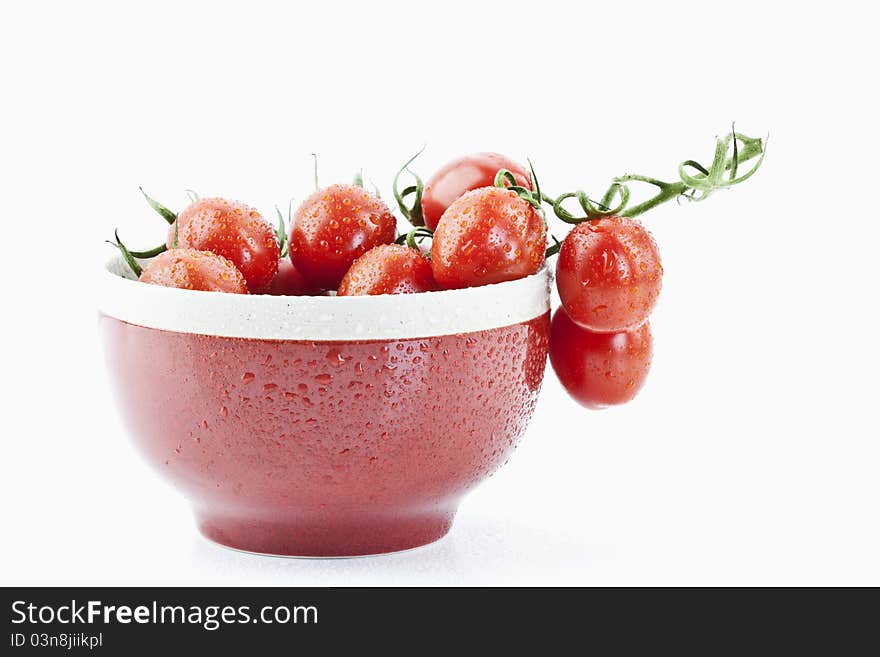 Tomatoes in a red bowl on white background. Tomatoes in a red bowl on white background