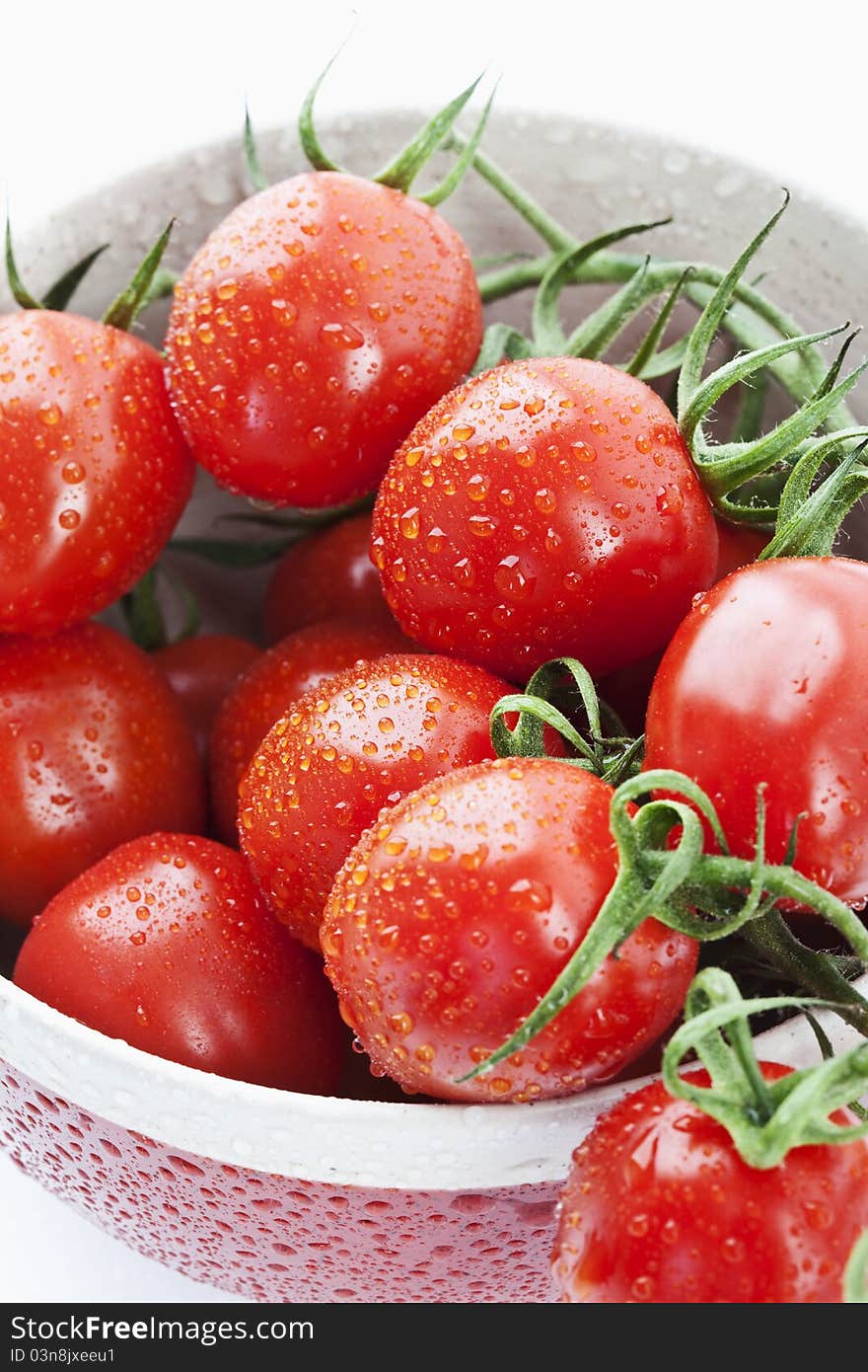 Tomatoes in a red bowl on white background. Tomatoes in a red bowl on white background