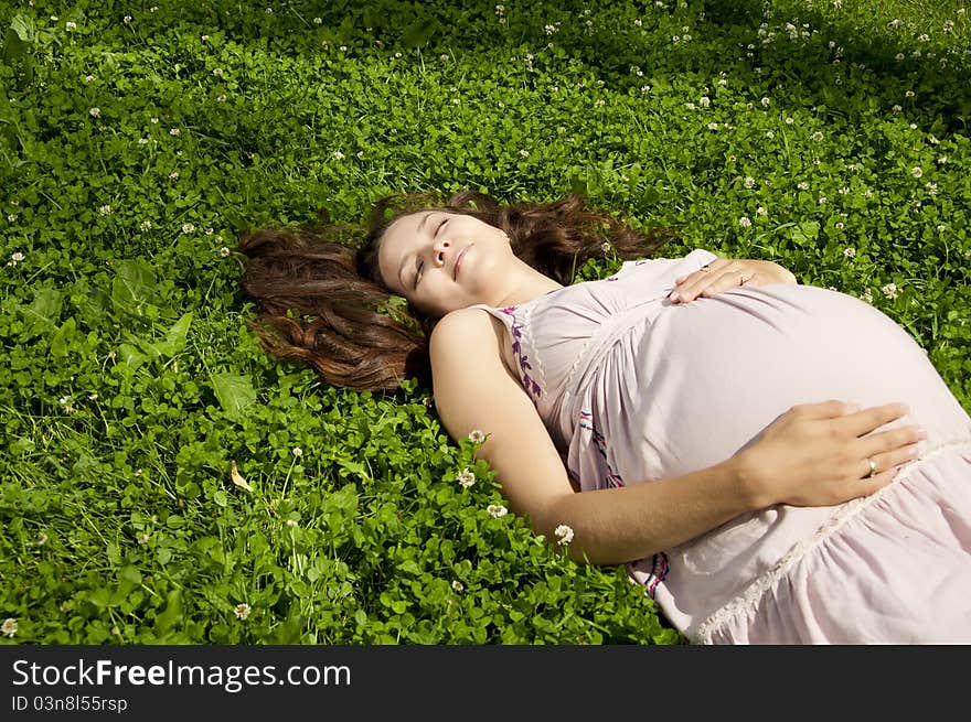 Beautiful pregnant woman relaxing in the park