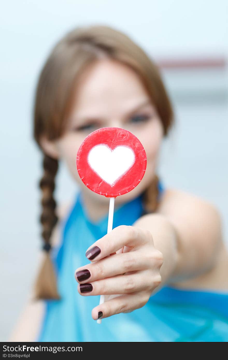 Young beautiful woman eating candy lollipops on white background.