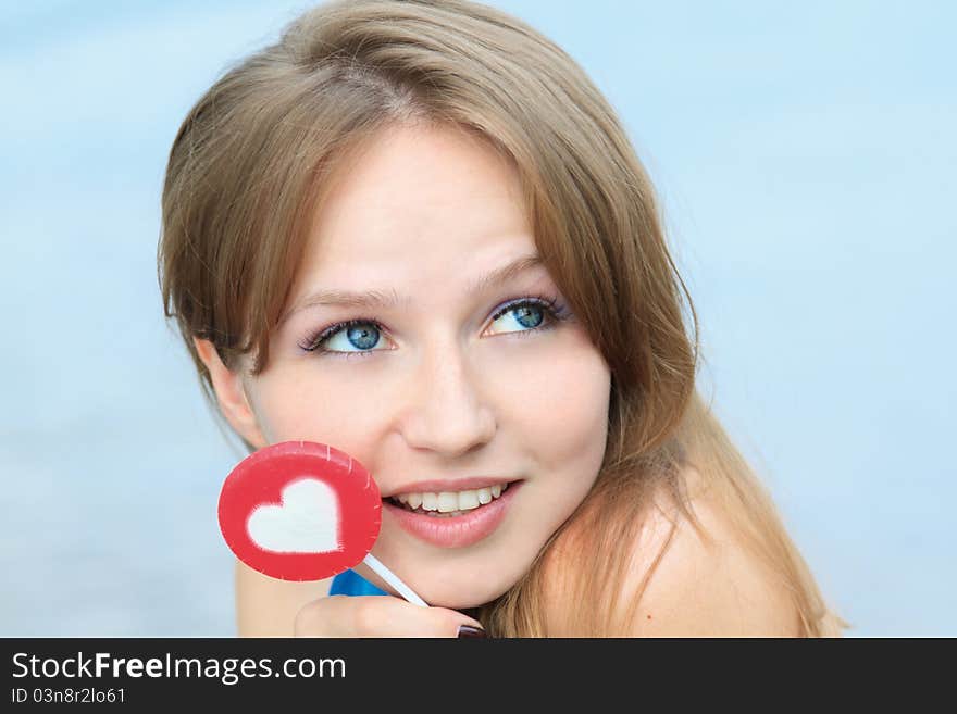 Young beautiful woman eating candy lollipops on white background.