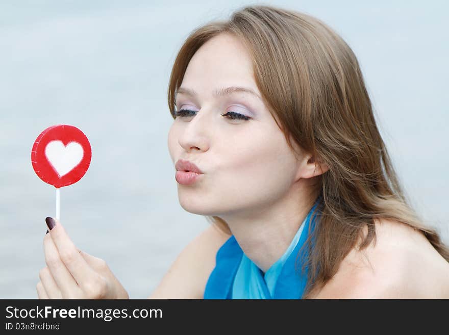 Young beautiful woman eating candy lollipops on white background.