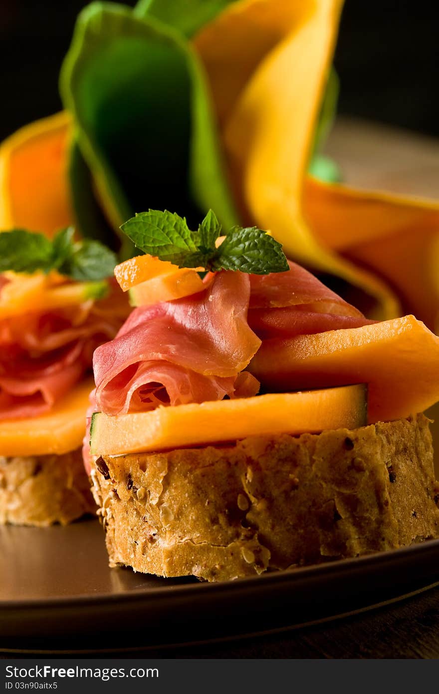 Photo of tasty bread slices with bacon and melon. Photo of tasty bread slices with bacon and melon