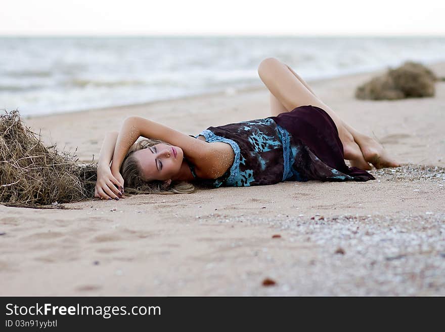 Beautiful fashionable model on the beach in beautiful dress