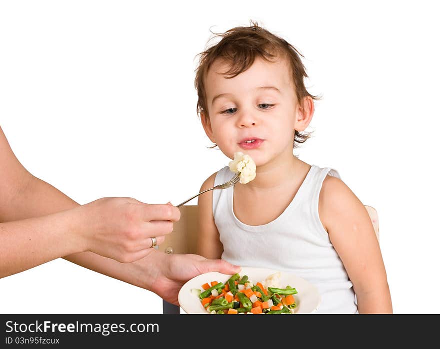 Little boy tasting vegetable salad isolated on white