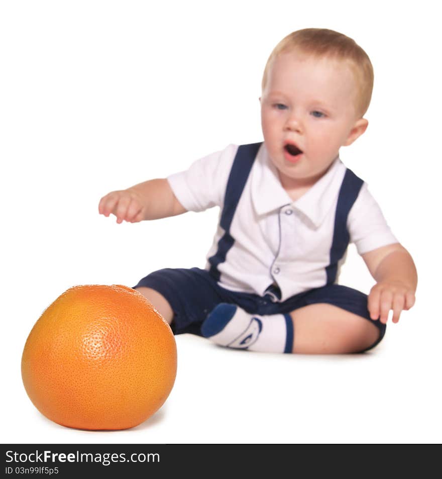 The child reaches out to orange, the focus on oranges, isolated on a white background. The child reaches out to orange, the focus on oranges, isolated on a white background