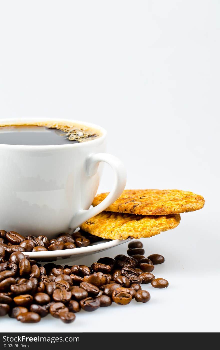 Chocolate cookies and a cup of coffee surrounded by coffee beans. Chocolate cookies and a cup of coffee surrounded by coffee beans