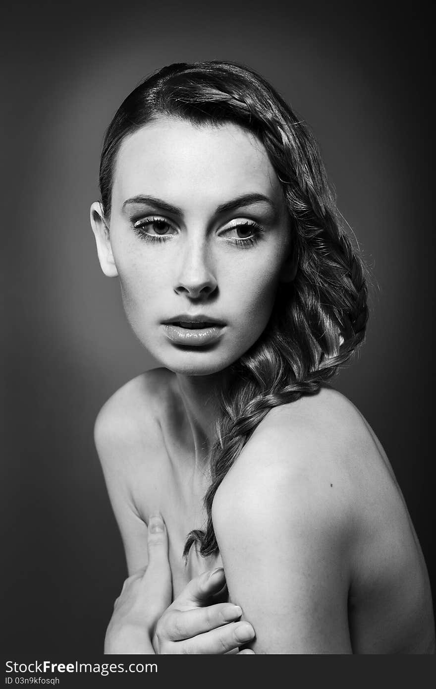 Close-up monochrome portrait of caucasian young woman with beautiful hairstyle on grey background. Close-up monochrome portrait of caucasian young woman with beautiful hairstyle on grey background