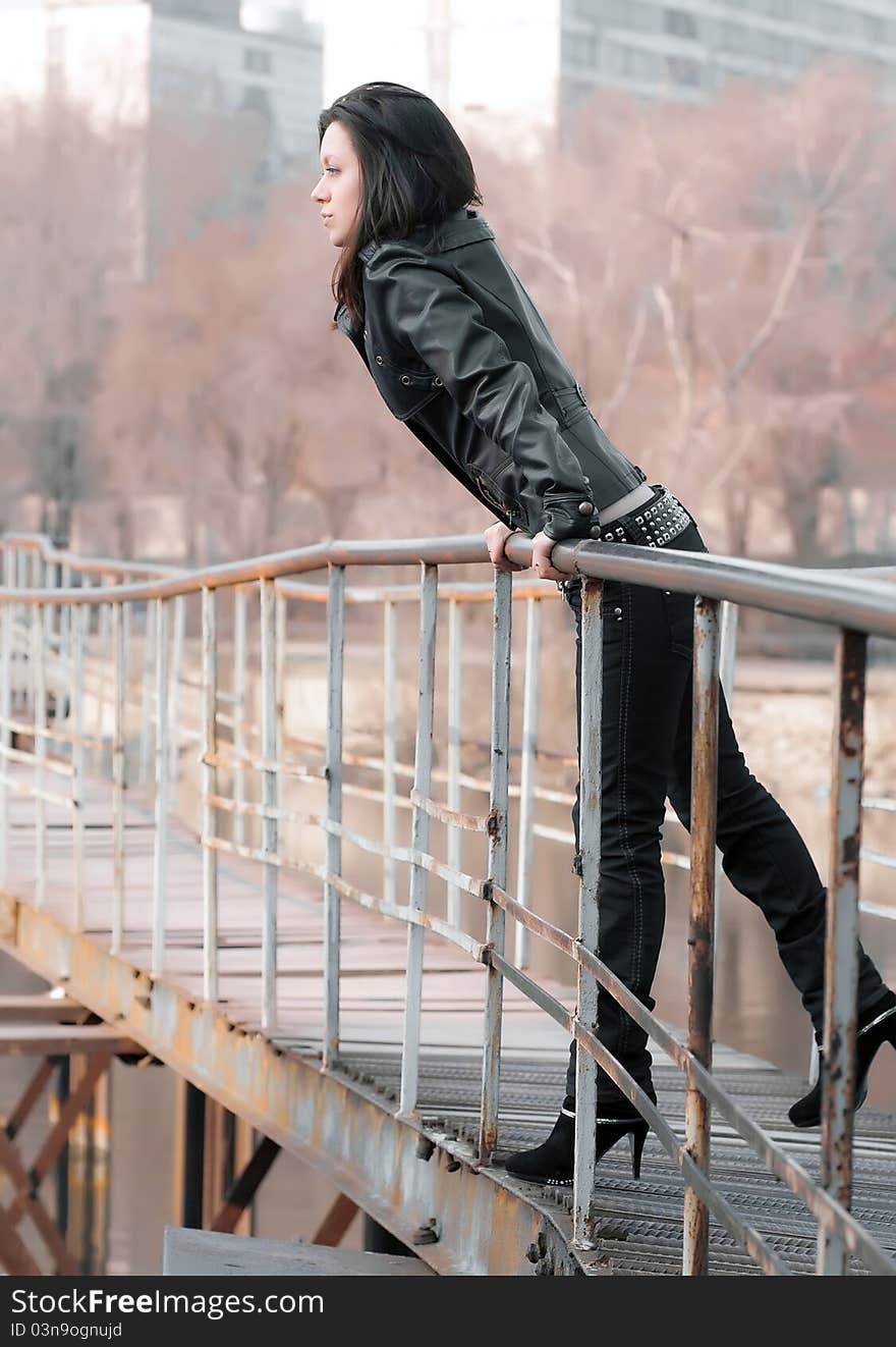 Girl on an iron bridge looks in the frame