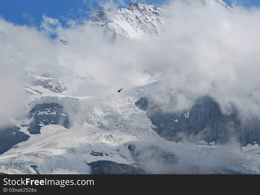 Snow mountian of Jungfraujoch in south of Swiss, a patrol helicopter within the mountain. Snow mountian of Jungfraujoch in south of Swiss, a patrol helicopter within the mountain