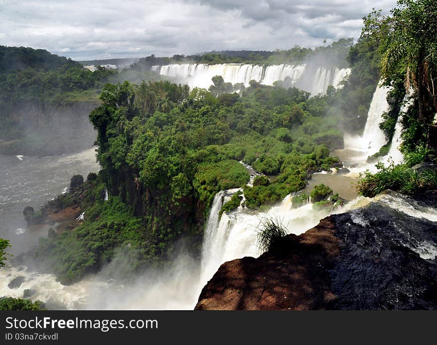 IguazÃº Falls, lie on the Argentina - Brazil border and are a UNESCO World Natural Heritage Site. IguazÃº Falls, lie on the Argentina - Brazil border and are a UNESCO World Natural Heritage Site.