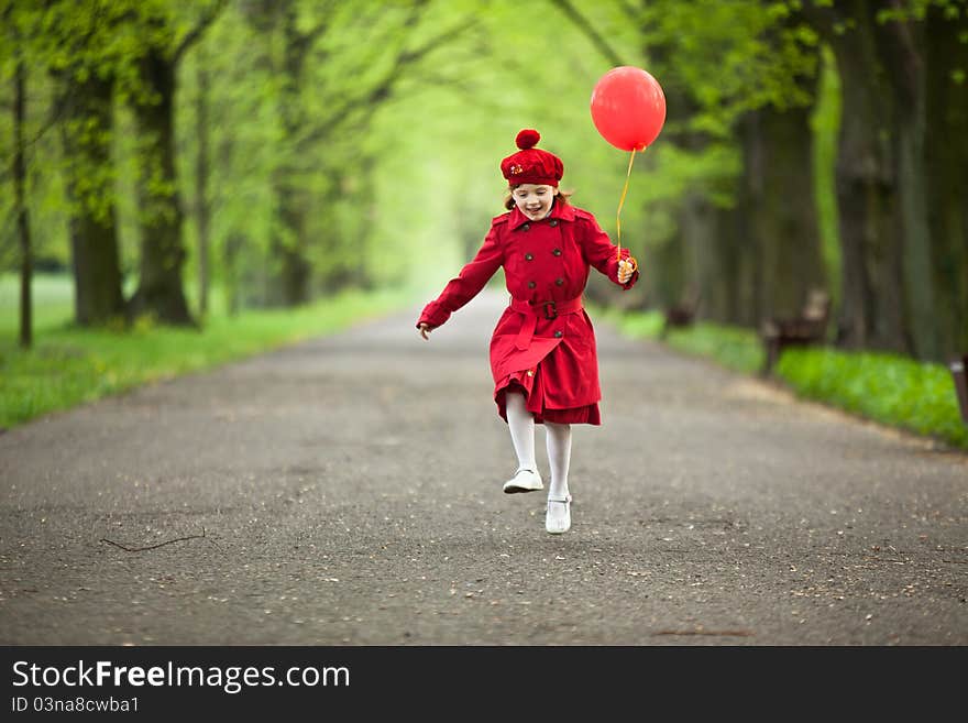 Girl wear in red coat, jumping in park alley, holding red balloon. Girl wear in red coat, jumping in park alley, holding red balloon