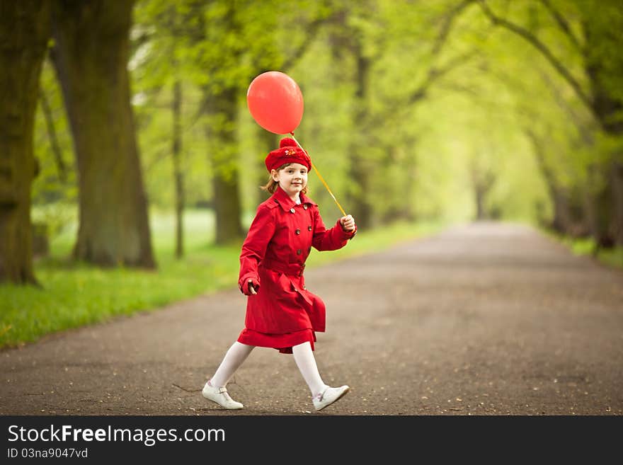 Girl wears in a red coat holding red balloon. Girl wears in a red coat holding red balloon