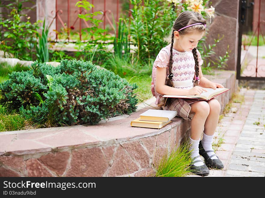 Young Girl With Bagpack Reads Waiting For School