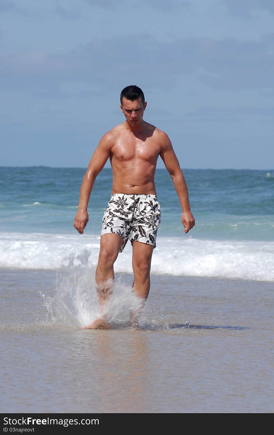 Latino man walking on a quiet beach. Latino man walking on a quiet beach