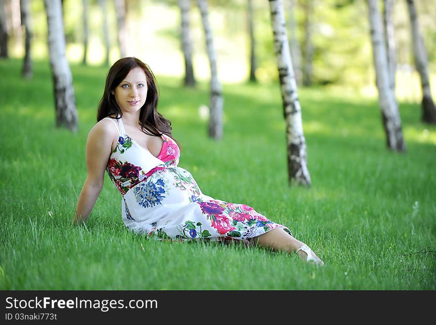 Beautiful woman sitting on grass in birch grove . summer's day. Beautiful woman sitting on grass in birch grove . summer's day.