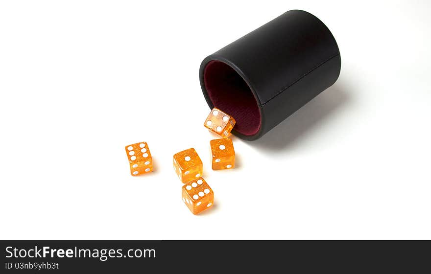 Five orange dice on a white background with a black rolling cup. Five orange dice on a white background with a black rolling cup