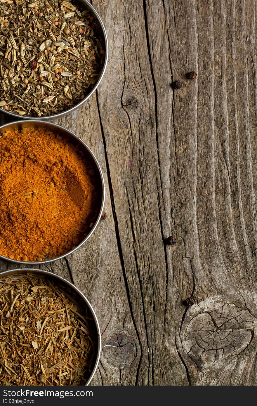 Mix of the spices on old wooden table as background