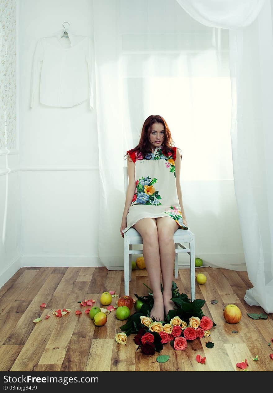 Portrait of a girl in the interior with flowers and apples