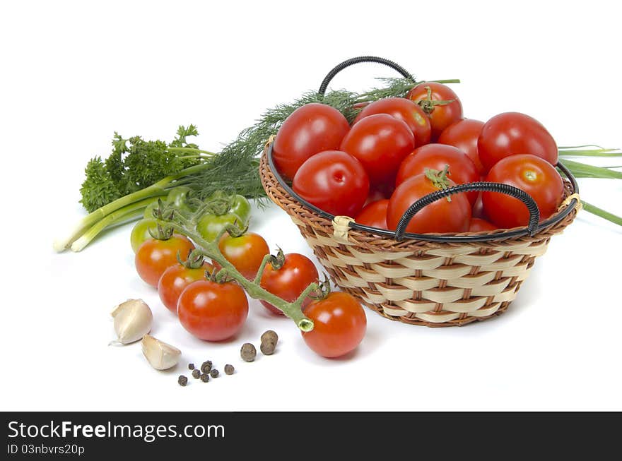 Tomatoes in basket and greens on white background. Tomatoes in basket and greens on white background